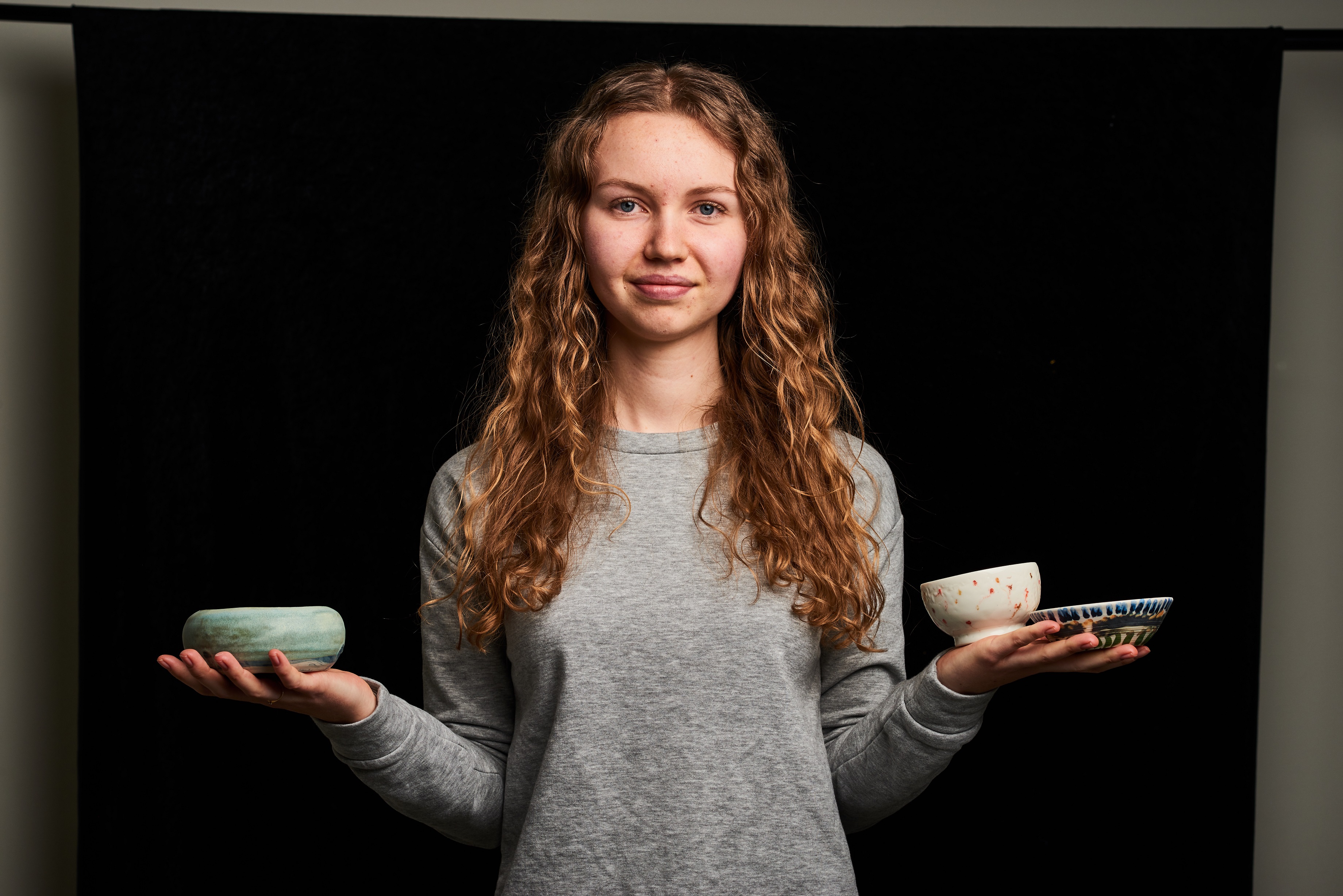 Jente som holder keramikk i hendene